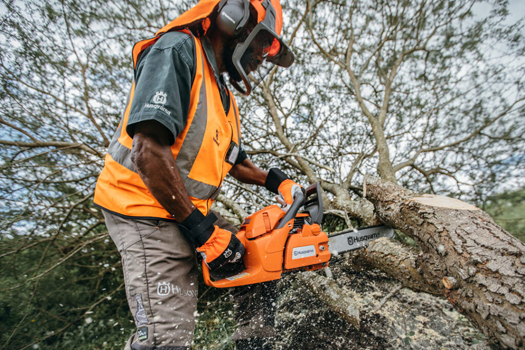Man cutting edge of a tree with a Husqvarna chainsaw
