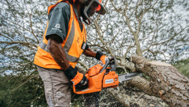 Man cutting edge of a tree with a Husqvarna chainsaw