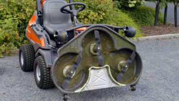 Front mower with it's blades lifted up outside a service centre.