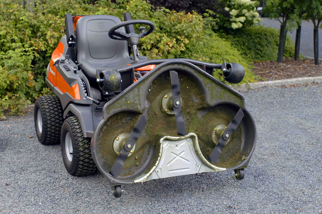 Front mower with it's blades lifted up outside a service centre.