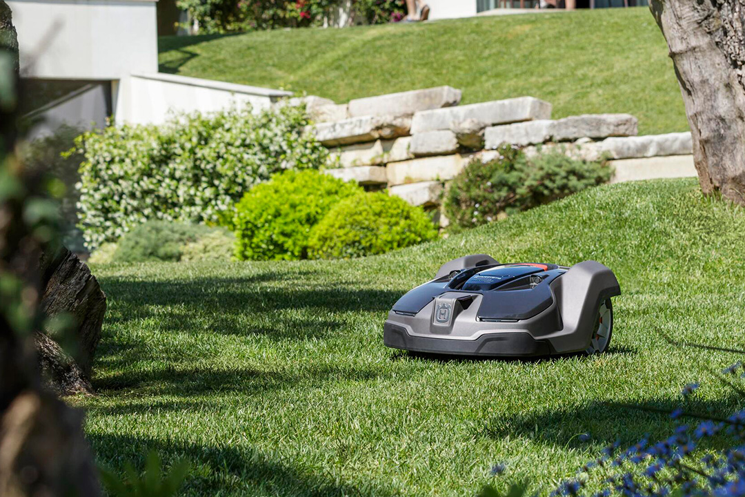 A Husqvarna robotic mower on a green lawn