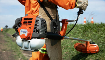 A man holding a brushcutter, one of the many Husqvarna products available in Zimbabwe.
