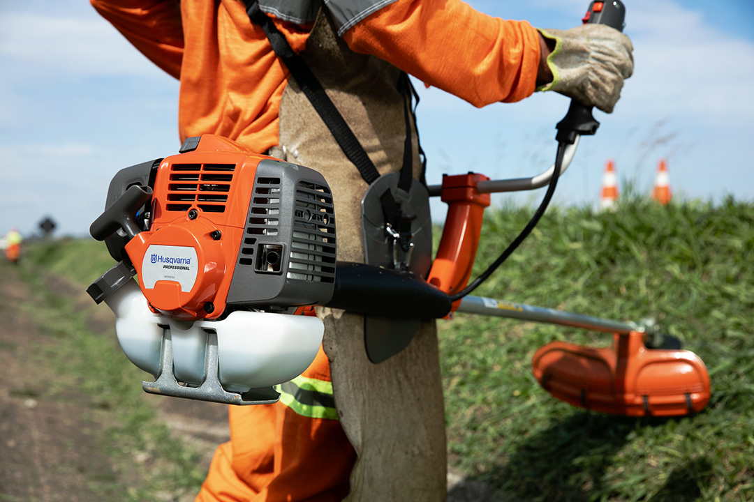 A man holding a brushcutter, one of the many Husqvarna products available in Zimbabwe.