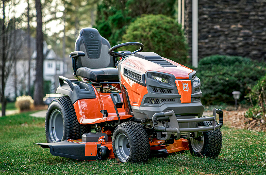 A Husqvarna TS 354 Garden Tractor mowing machine in a picturesque garden.