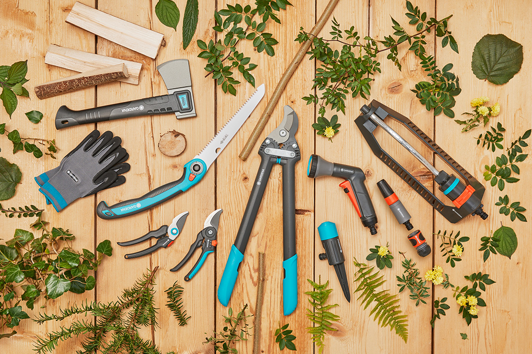 A range of high-quality GARDENA products lying on a wooden table