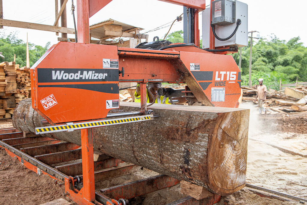 A Wood-Mizer LT15 sawmill cutting through a large tree in Zimbabwe