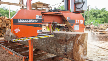 A Wood-Mizer LT15 sawmill cutting through a large tree in Zimbabwe