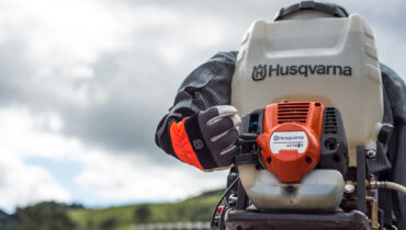 a man wearing a husqvarna 325s25 sprayer for tobacco